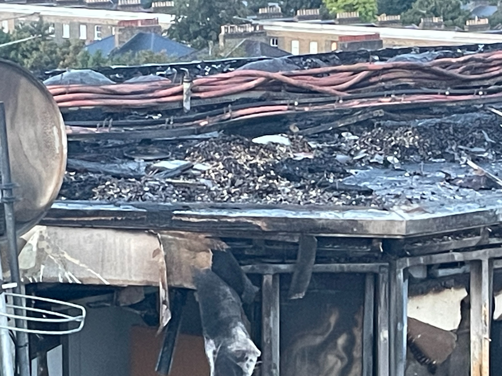 Fire-damaged roof edge, photovoltaic cabling and building structure
