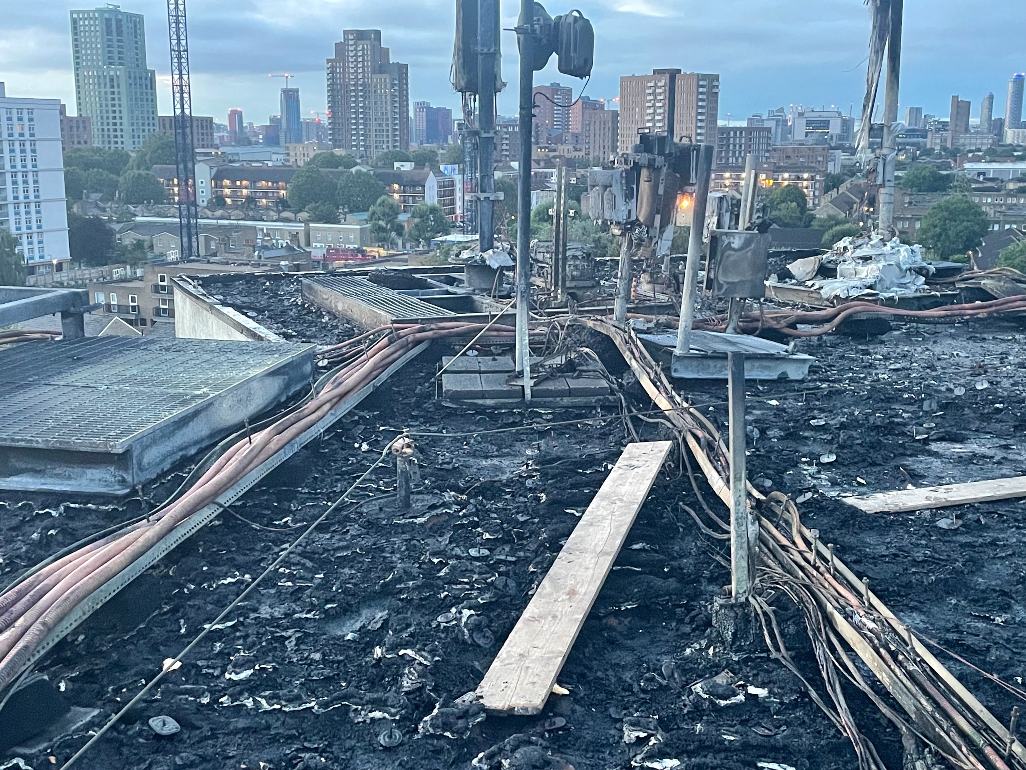 Fire-damaged rooftop with photovoltaic cabling and equipment visible