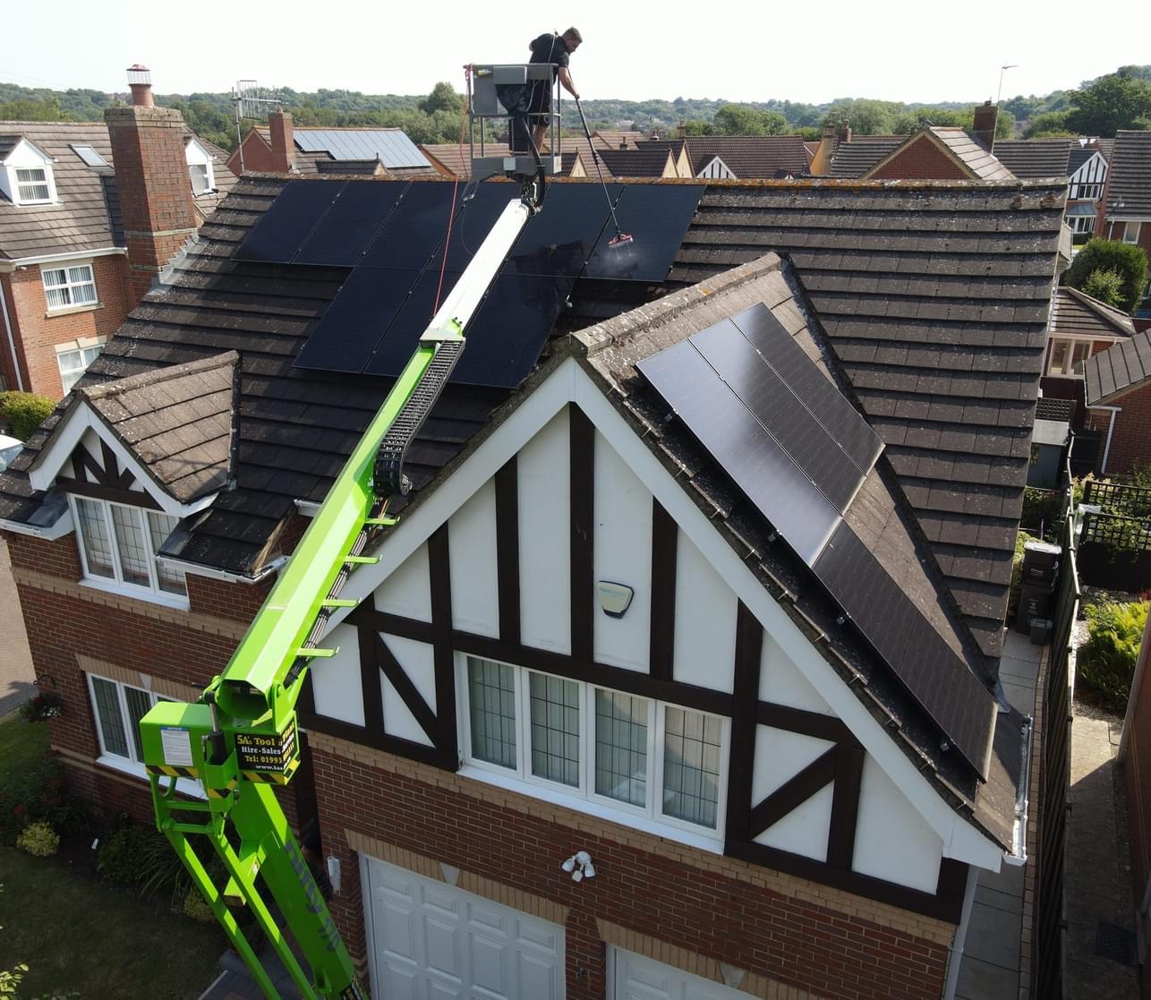Residential solar panel cleaning from a planned boom lift access position