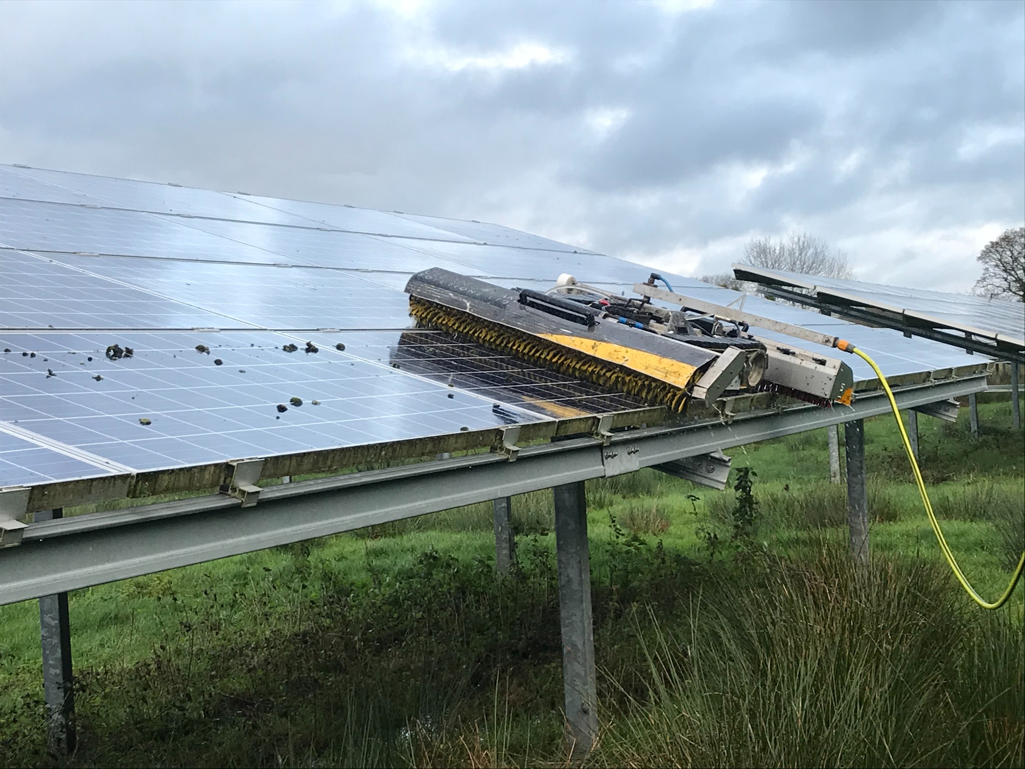 Robotic cleaning machine operating on a utility-scale ground-mounted solar array